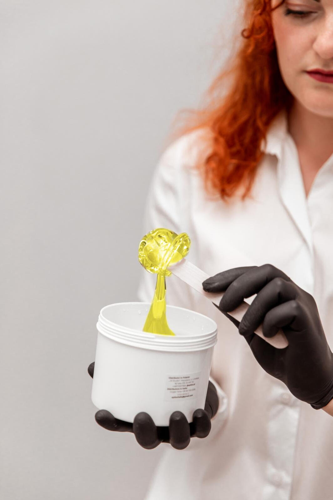 Depilacja cukrowa w gabinecie LuxeSkin w mieście Toruń – naturalna pasta cukrowa nakładana na patyczek Nakładanie pasty cukrowej na patyczek – przygotowanie do depilacji cukrowej w gabinecie LuxeSkin w Toruniu